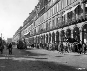 American and French tanks roll through Rue De Rivoli in Paris as cheering crowds celebrate the 1944 liberation