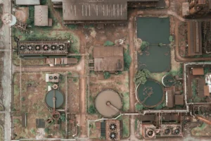 Aerial view of an abandoned industrial plant with rusty storage tanks, evoking historical industrial disasters