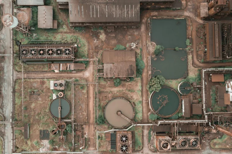 Aerial view of an abandoned industrial plant with rusty storage tanks, evoking historical industrial disasters