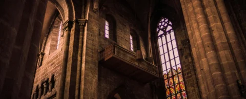 Medieval philosopher contemplating God's existence through ontological argument manuscript