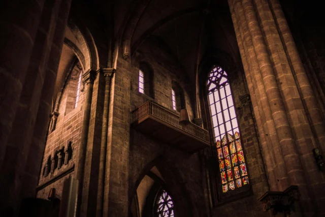 Medieval philosopher contemplating God's existence through ontological argument manuscript