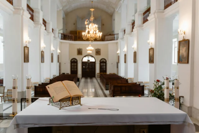 Rows of unlit prayer candles in an empty church