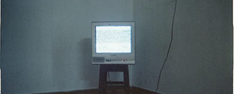 Dark living room with television displaying static, symbolizing prestige television endings gone wrong
