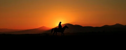 Silhouette against sunset sky representing Western genre revival imagery