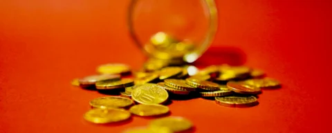 Gold coins and currency symbolizing the self-made billionaire myth and inherited wealth