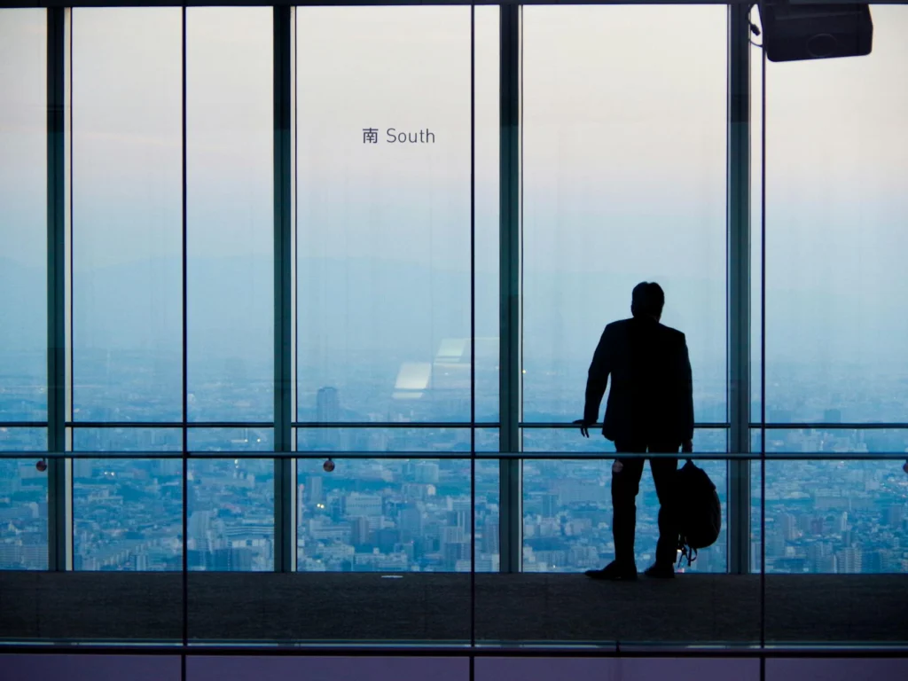 Lone figure in corporate hallway illustrating whistleblower retaliation psychology