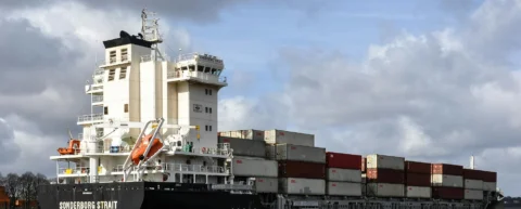 Cargo ships navigating through maritime chokepoints that control global trade routes