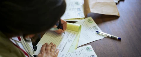 Stacks of medical billing paperwork representing healthcare administrative costs