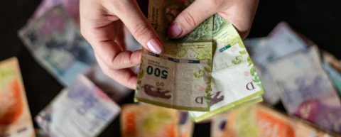 Cash in hand representing basic income experiments and unconditional payments