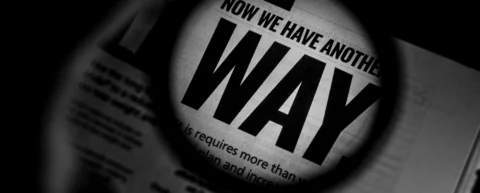 Magnifying glass over newspaper illustrating circular reporting investigation