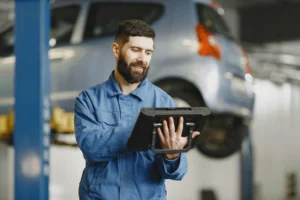 Mechanic using diagnostic tablet to navigate software repair locks on vehicle