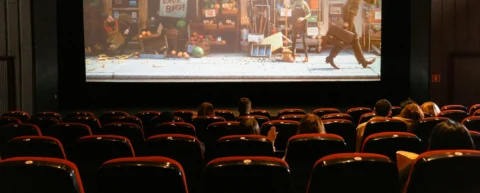 Cinema audience watching a film with longer movie runtimes in a darkened theater