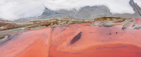 Aerial view of lithium extraction pools illustrating the geopolitics of lithium cartelization