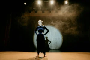 Actress in spotlight representing prestige casting economics in modern Hollywood