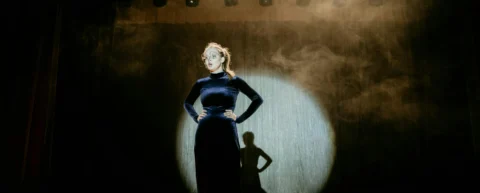 Actress in spotlight representing prestige casting economics in modern Hollywood