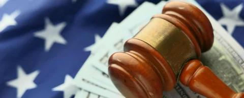 Courtroom gavel beside stacks of currency representing litigation funding as financial asset