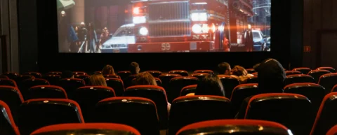 Audience experiencing disaster film psychology in darkened theater