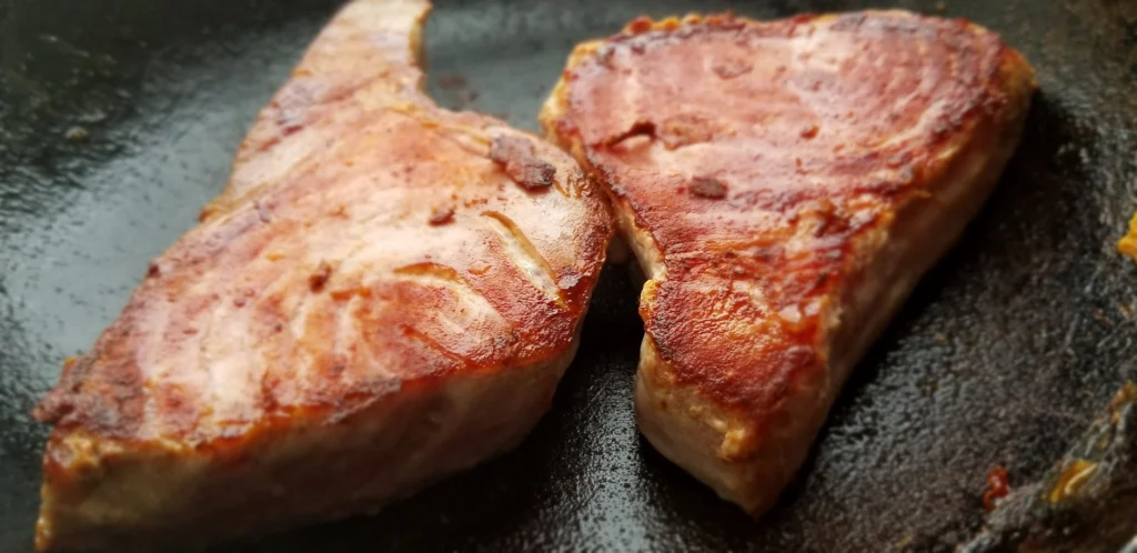 Steak searing in a pan demonstrating cooking heat chemistry and the Maillard reaction