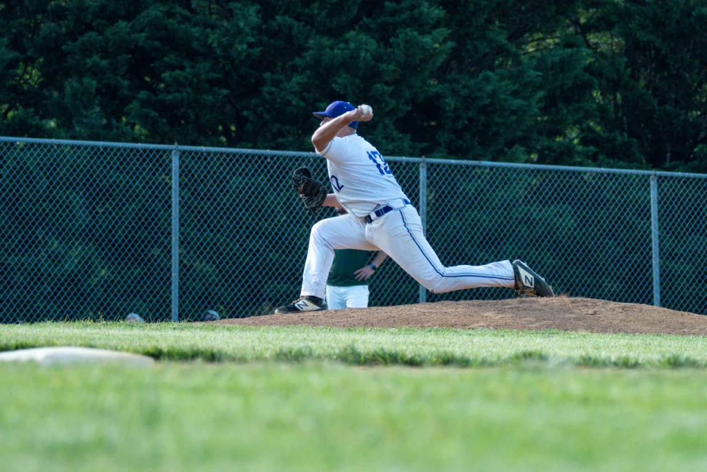 Relief pitcher mid-delivery, illustrating the reliever workload that loads the throwing shoulder